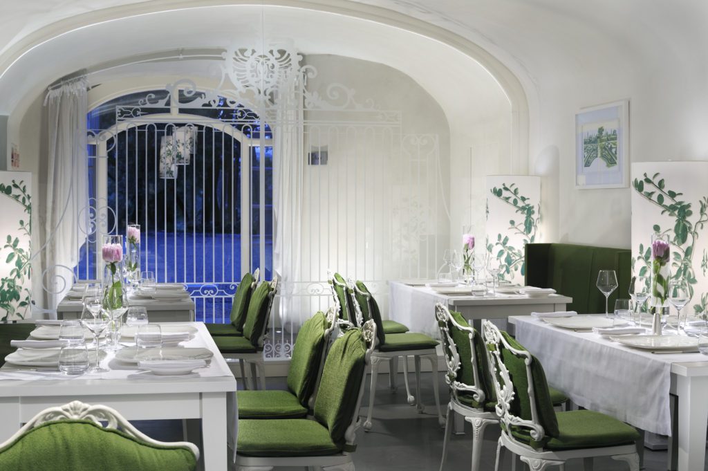Italian restaurant with green chairs and white tablecloths